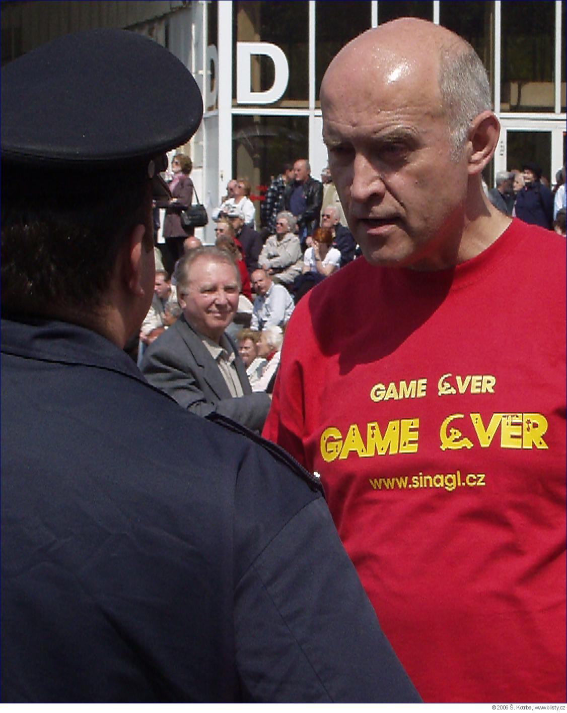 Aktivista Šinágl vysvětluje policistům, že by měli konat a zasáhnout proti prvomájovému setkání komunistů.